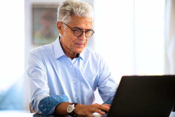 hotelier knowing more about hotel cancellation policies on laptop