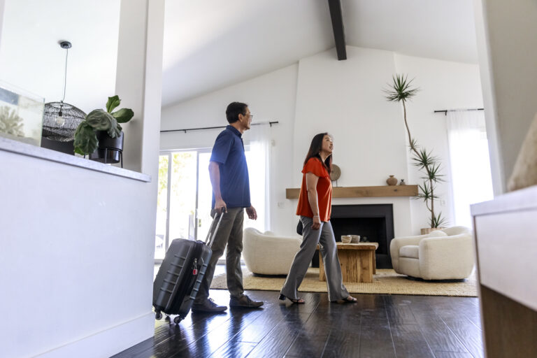 Couple with their luggage walking into a beautiful vacation rental.