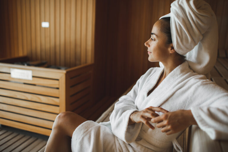 Woman smiling and relaxing in a hotel sauna.