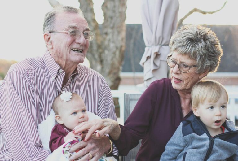 Elderly couple holding their grandchildren