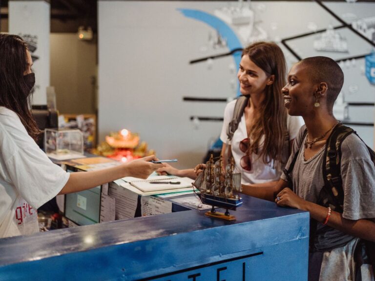 Two young women speaking with a hotel lobby attendant